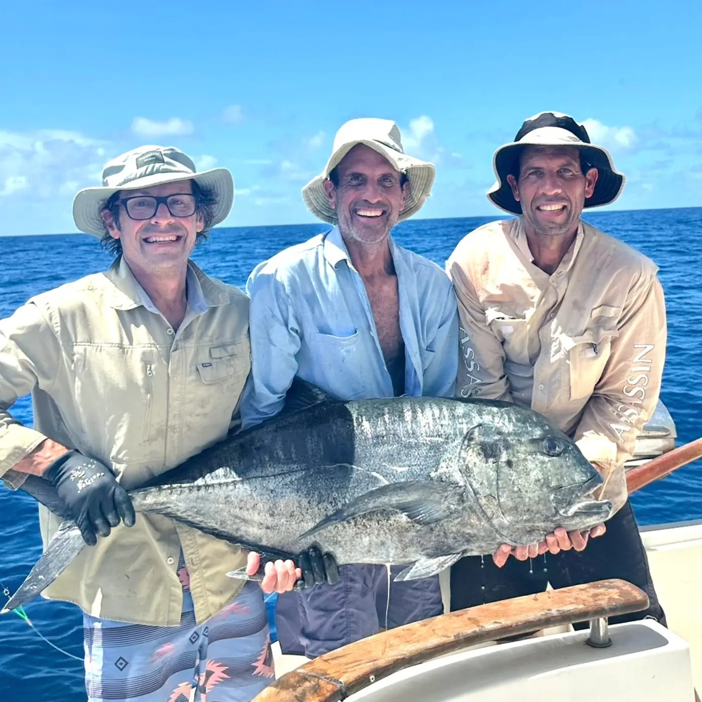 Anglers holding a giant trevally caught on a popper in the Seychelles Outer Islands