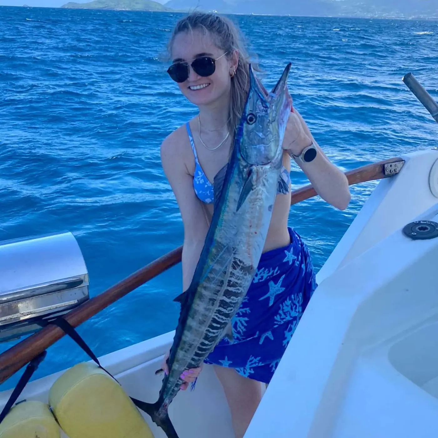 Angler holding a wahoo aboard the boat