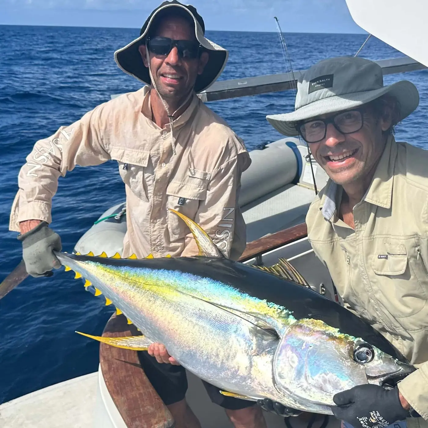 Two anglers holding a yellowfin tuna aboard a Seychelles liveaboard