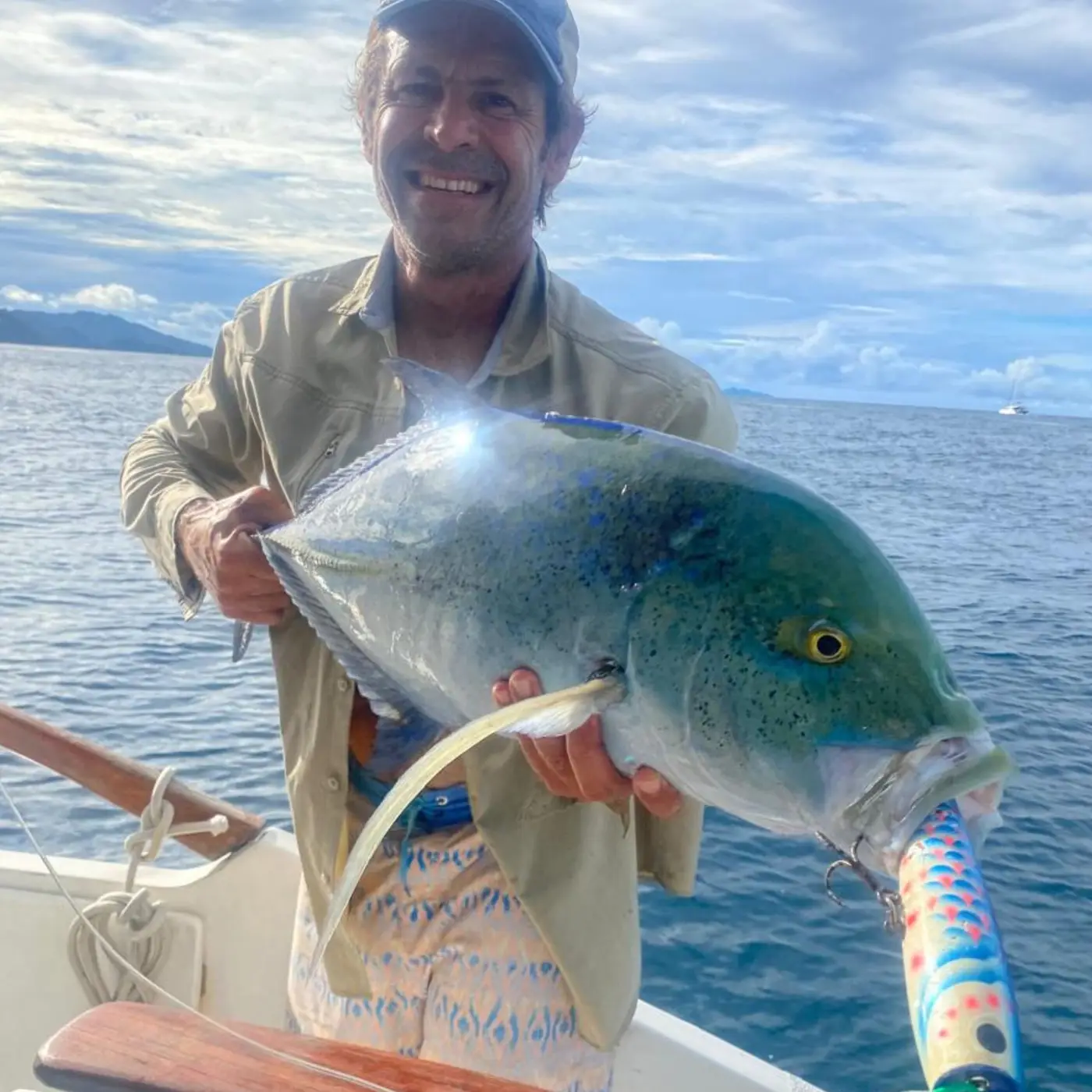 Angler holding a bluefin trevally with a popper